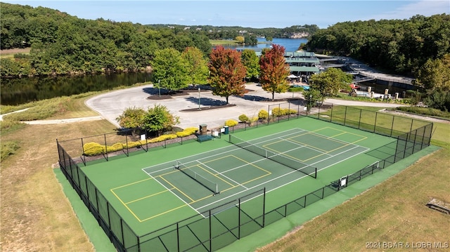 view of sport court featuring a water view and fence