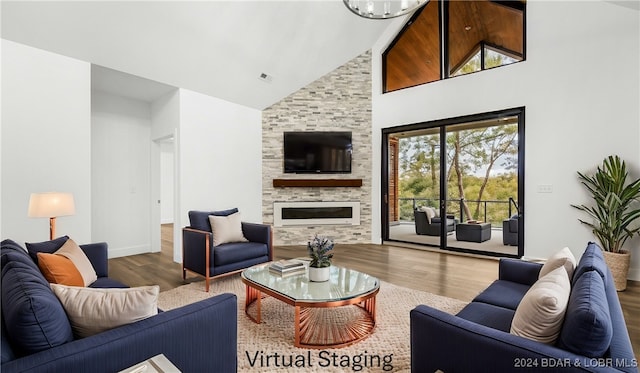 living room featuring a large fireplace, baseboards, visible vents, wood finished floors, and high vaulted ceiling