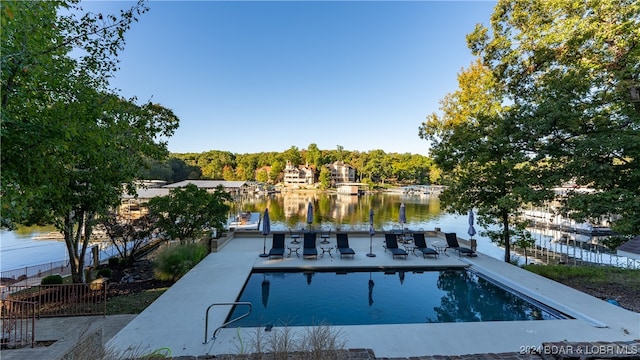 view of swimming pool with a water view and a patio