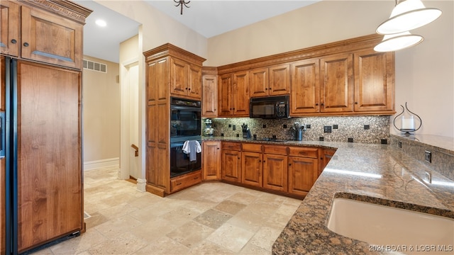 kitchen featuring sink, hanging light fixtures, dark stone counters, decorative backsplash, and black appliances