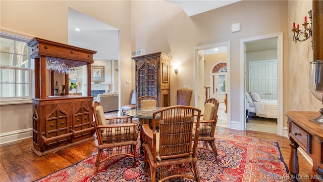 living area with hardwood / wood-style floors and a towering ceiling