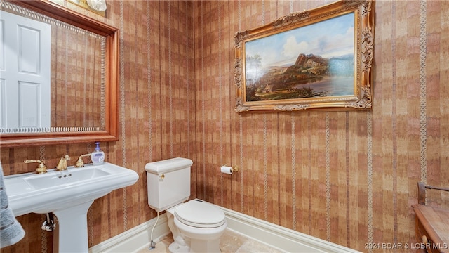 bathroom featuring tile patterned floors, wood walls, and toilet