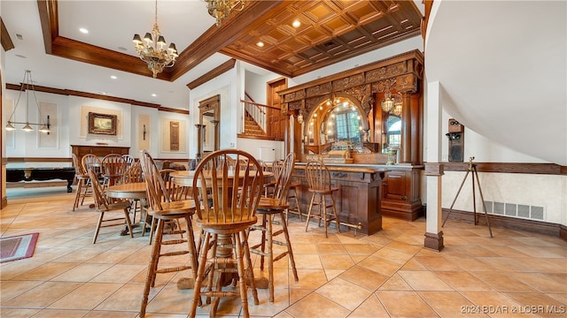 tiled dining room with a high ceiling, indoor bar, crown molding, and a notable chandelier