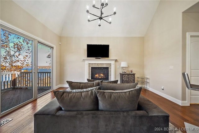 living room featuring wood-type flooring, lofted ceiling, and a notable chandelier