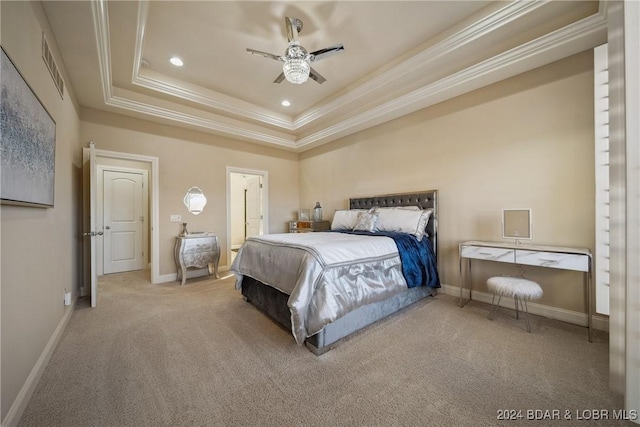 carpeted bedroom with a tray ceiling, ceiling fan, and crown molding