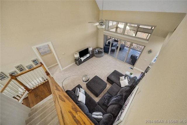 carpeted living room featuring ceiling fan and high vaulted ceiling