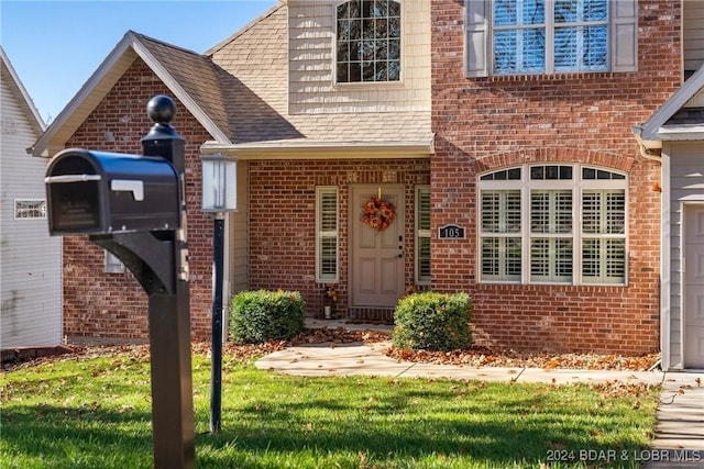 view of exterior entry with a lawn