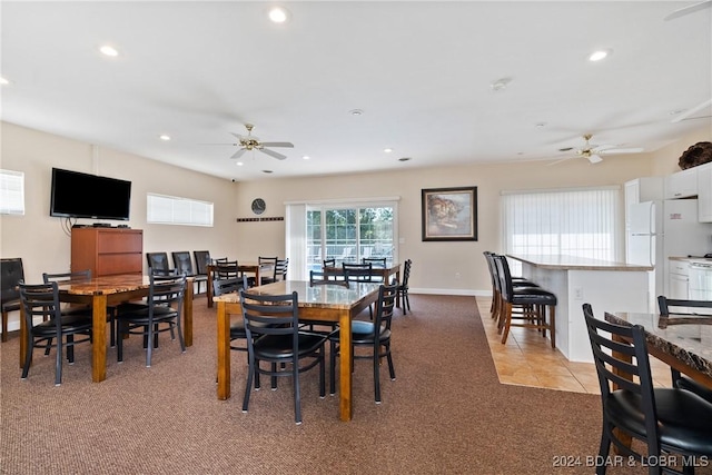 carpeted dining space with ceiling fan