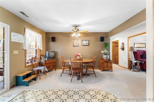 carpeted dining space featuring ceiling fan