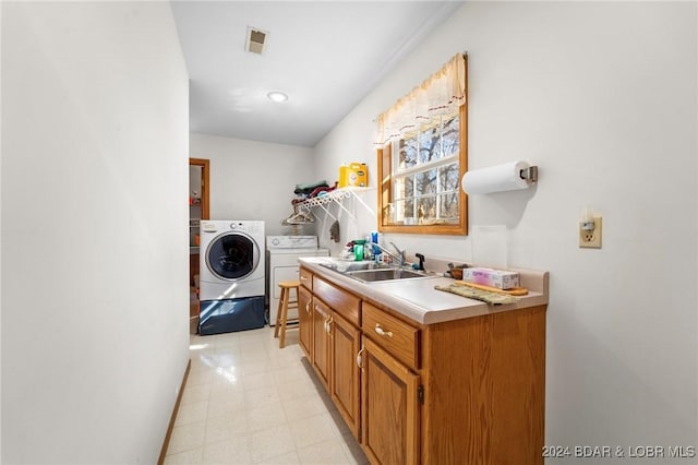 laundry room with separate washer and dryer and sink