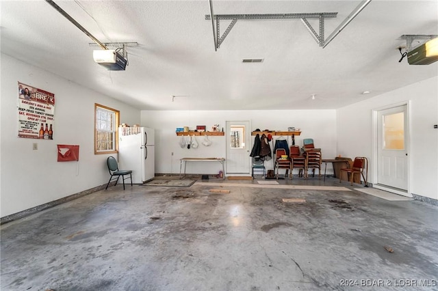 garage with white fridge and a garage door opener