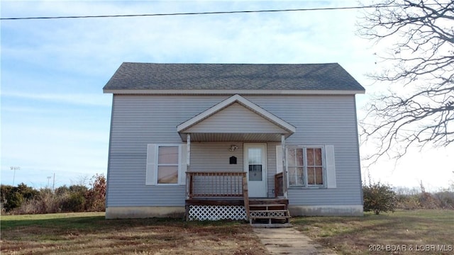 view of front of home with a front yard and a porch