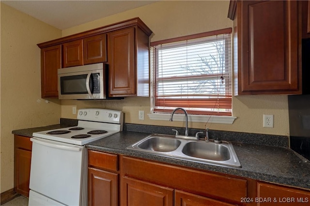 kitchen featuring white range with electric stovetop and sink