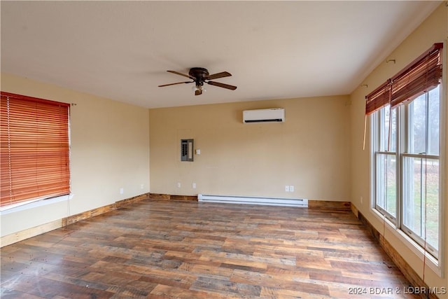 spare room with a baseboard radiator, plenty of natural light, a wall mounted AC, and hardwood / wood-style flooring