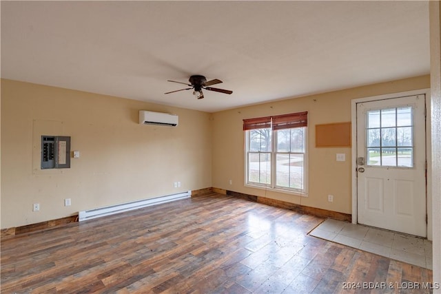 interior space featuring wood-type flooring, plenty of natural light, baseboard heating, and a wall unit AC