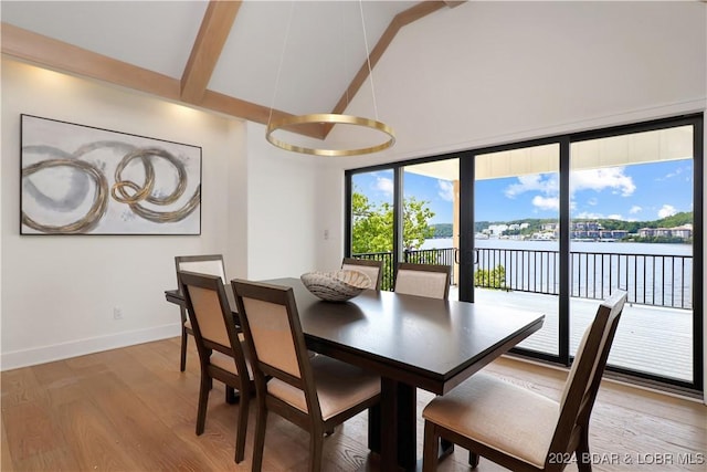 dining room with beamed ceiling, wood-type flooring, and a water view