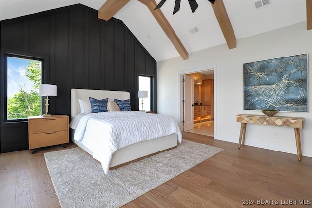 bedroom featuring vaulted ceiling with beams, ensuite bathroom, ceiling fan, and wood-type flooring