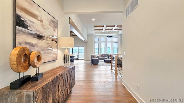 hallway with beamed ceiling, wood-type flooring, and coffered ceiling