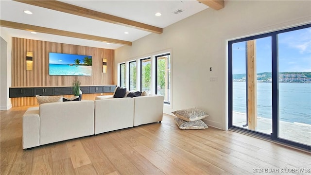 living room featuring beam ceiling, a water view, and light hardwood / wood-style floors