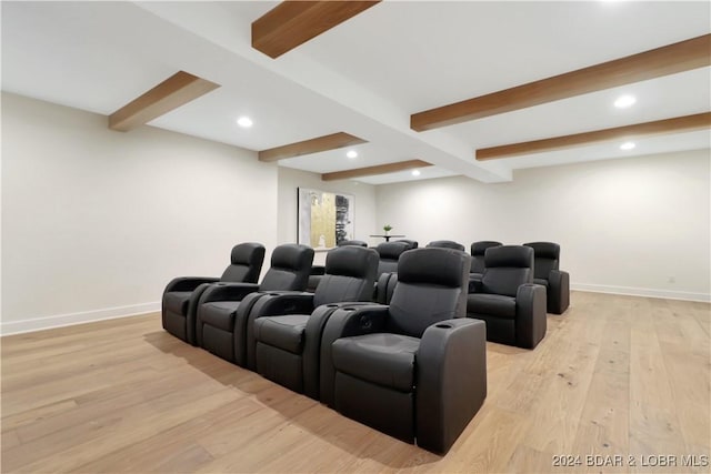 cinema featuring beamed ceiling and light wood-type flooring