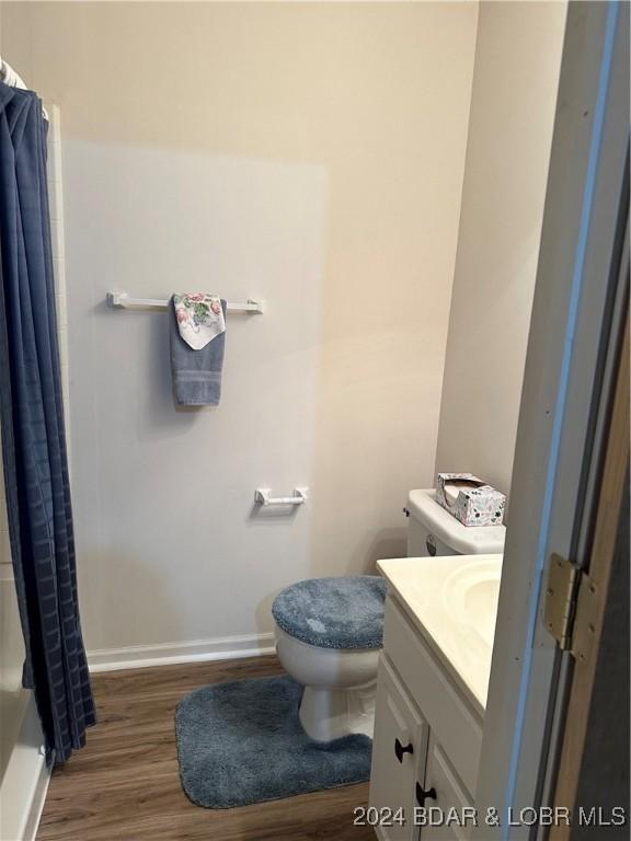 bathroom with hardwood / wood-style flooring, vanity, and toilet