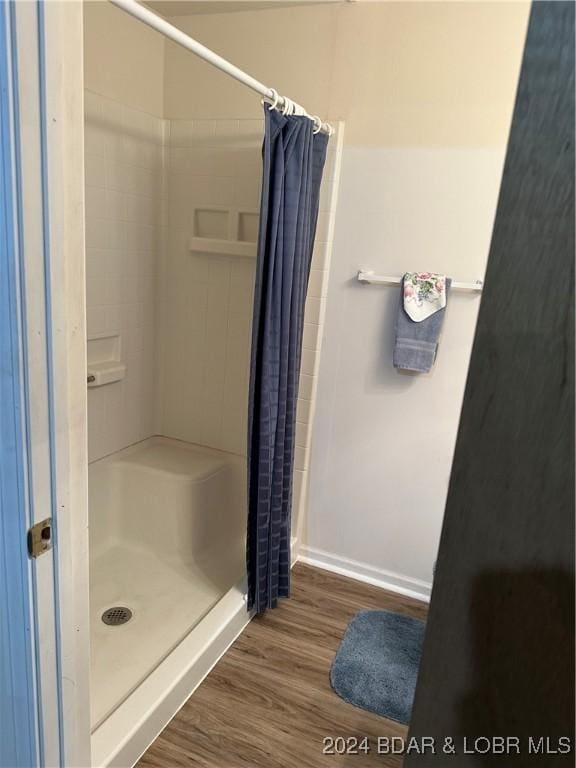 bathroom featuring hardwood / wood-style floors and curtained shower