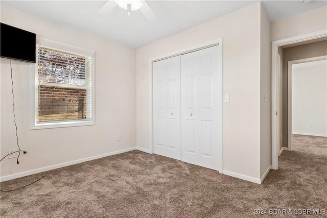 unfurnished bedroom with ceiling fan, carpet floors, and a closet