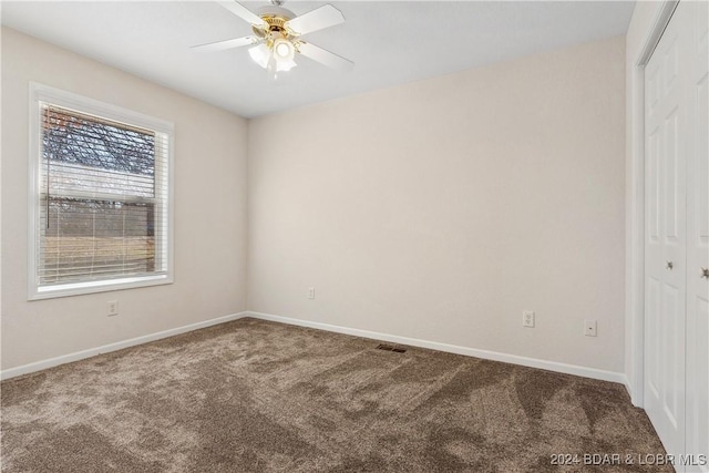 empty room with ceiling fan and carpet flooring