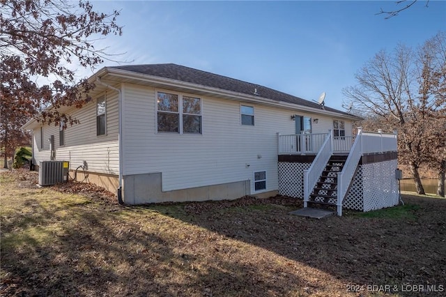 back of house with central AC unit and a deck