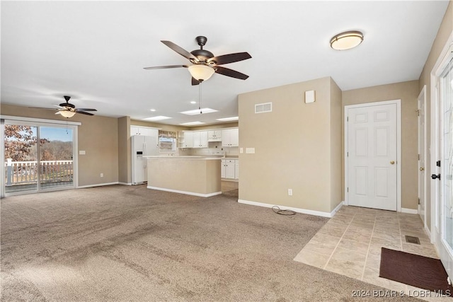 unfurnished living room featuring ceiling fan and light colored carpet