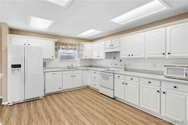 kitchen with white cabinetry, white appliances, and sink