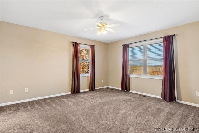 spare room with plenty of natural light, carpet, and ceiling fan