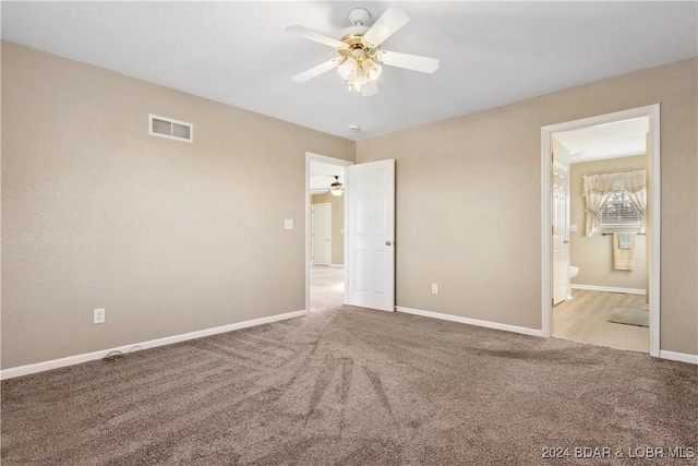 unfurnished bedroom with connected bathroom, light colored carpet, and ceiling fan