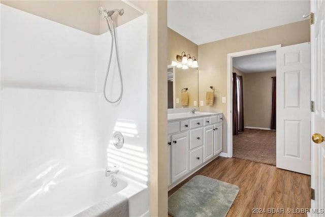 bathroom with hardwood / wood-style flooring, vanity, and bathing tub / shower combination