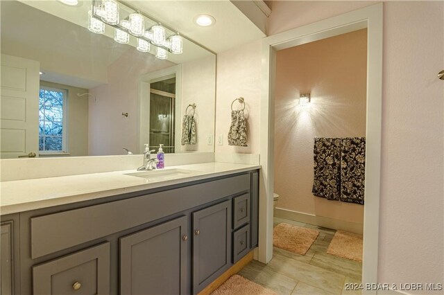 bathroom featuring baseboards, recessed lighting, toilet, and vanity