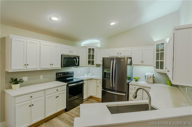 kitchen with a sink, glass insert cabinets, backsplash, vaulted ceiling, and appliances with stainless steel finishes
