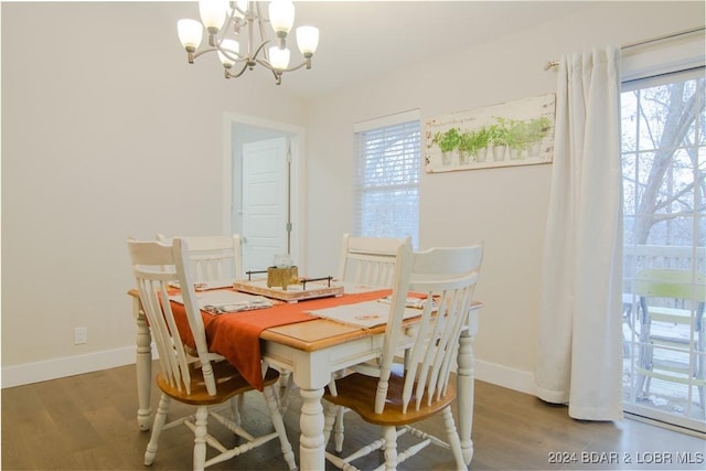dining area featuring an inviting chandelier, wood finished floors, and baseboards