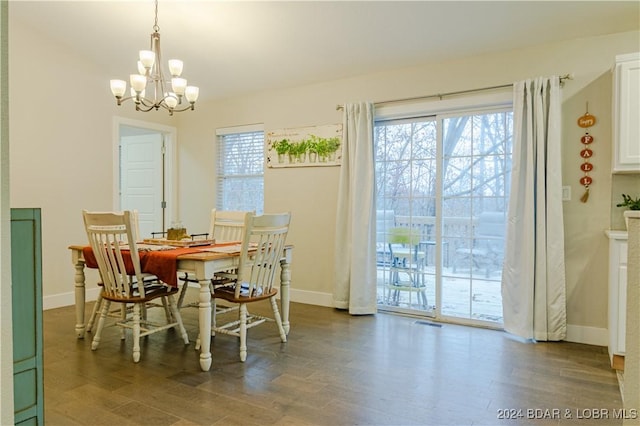 dining space featuring plenty of natural light, dark hardwood / wood-style flooring, and an inviting chandelier