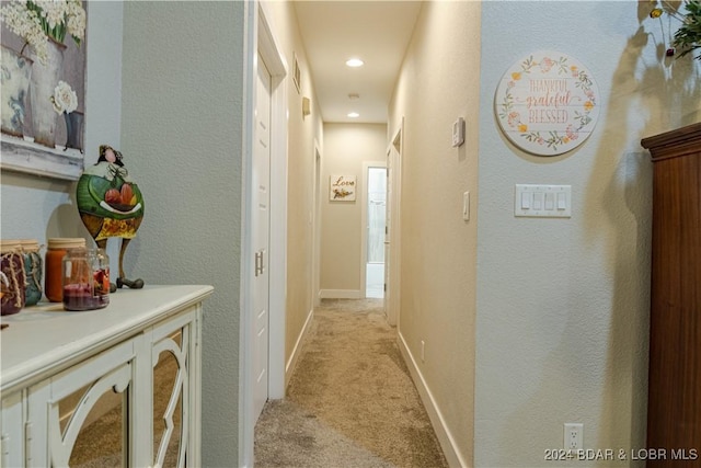corridor featuring recessed lighting, light colored carpet, and baseboards