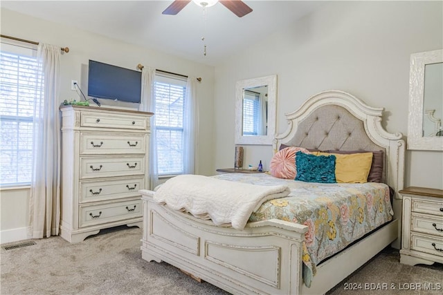 bedroom featuring visible vents, baseboards, vaulted ceiling, light carpet, and a ceiling fan