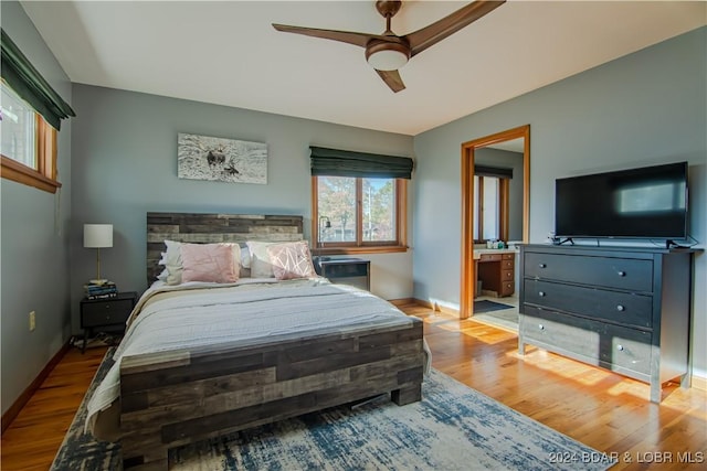 bedroom with ceiling fan, ensuite bathroom, and light hardwood / wood-style flooring