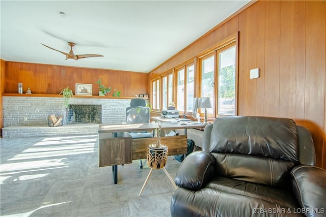 interior space with ceiling fan and wooden walls