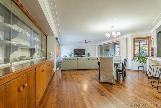 dining room with hardwood / wood-style floors, ceiling fan with notable chandelier, and ornamental molding