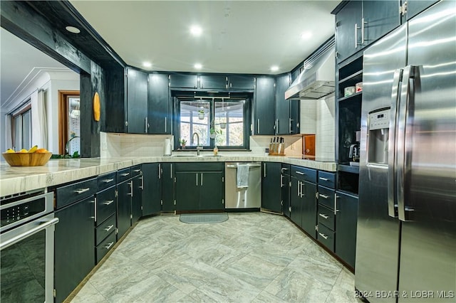 kitchen with extractor fan, sink, ornamental molding, stainless steel appliances, and light stone countertops