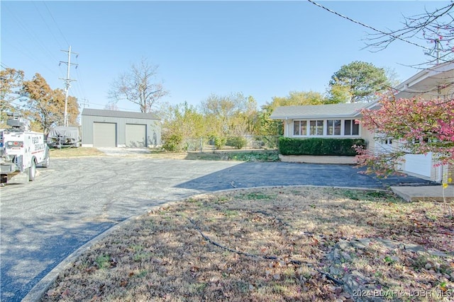 view of yard with a garage and an outbuilding