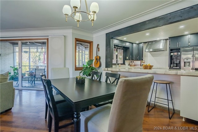 dining space with dark hardwood / wood-style flooring, crown molding, and a chandelier