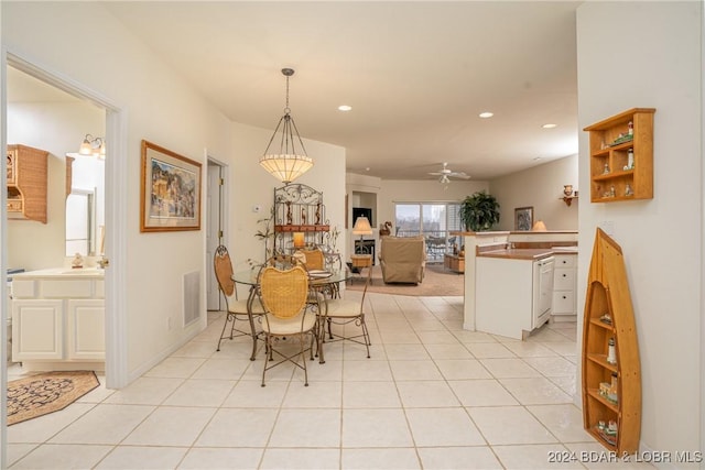 tiled dining room with ceiling fan and sink