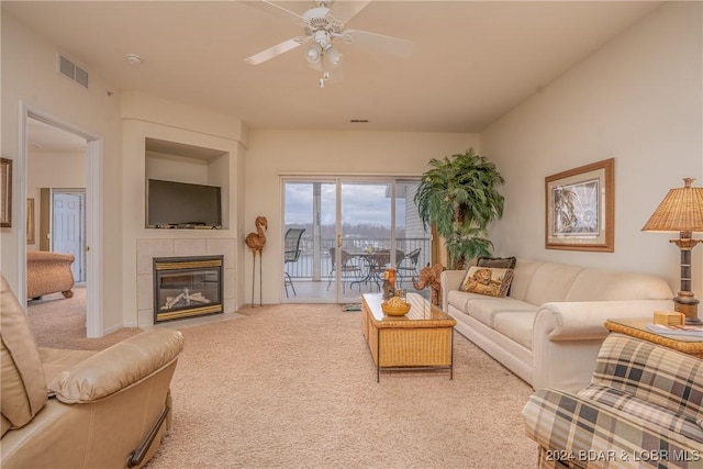 carpeted living room featuring a fireplace and ceiling fan