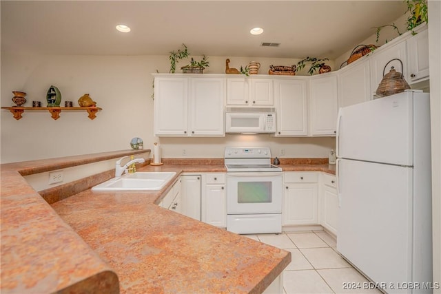 kitchen featuring sink, light tile patterned floors, kitchen peninsula, white appliances, and white cabinets