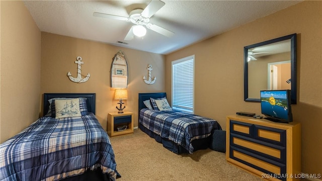 carpeted bedroom with ceiling fan and a textured ceiling